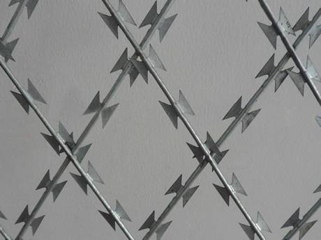 Komad zavarene mreže od nehrđajućeg čelika sa dijamantskim otvorom na sivoj pozadini.